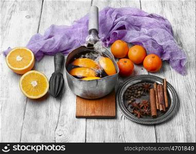 Hot wine with oranges. Warmed red wine in retro scoop with spices