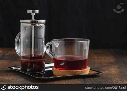 Hot winter tea served with a french press on a wooden floor