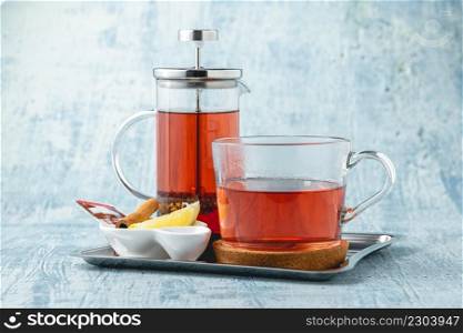 Hot winter tea served with a french press on a wooden table