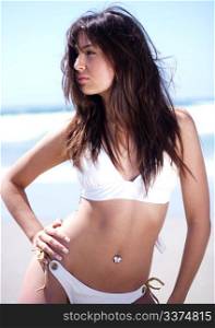 Hot young sexy model posing in white bikini by the beach