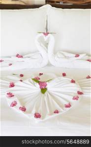 Hotel Bedroom With Flowers Arranged On Sheets