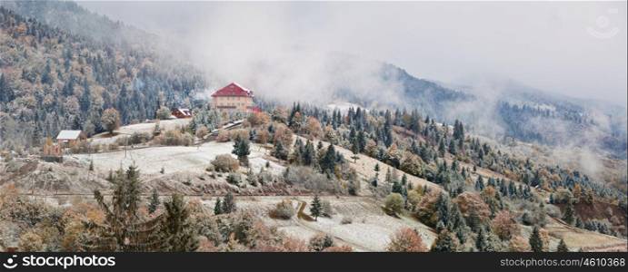 Hotel in mountains. Snow and fog. First snow in autumn. Snowfall in mountains
