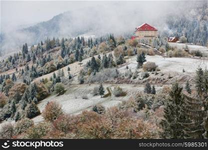 Hotel in mountains. Snow and fog. Winter coming in Carpathians.
