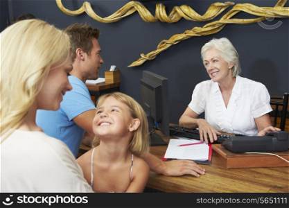 Hotel Receptionist Helping Family To Check In