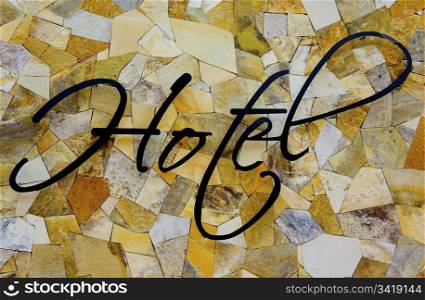 Hotel sign on yellow granit pieces background.