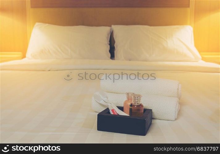 Hotel towel set with toothbrush and toothpaste on white bed