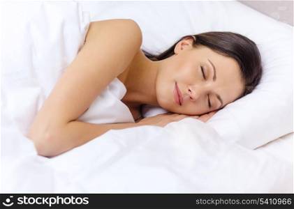 hotel, travel and happiness concept - beautiful woman sleeping in bed