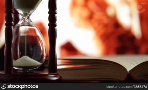 hourglass and book on background of the fireplace.
