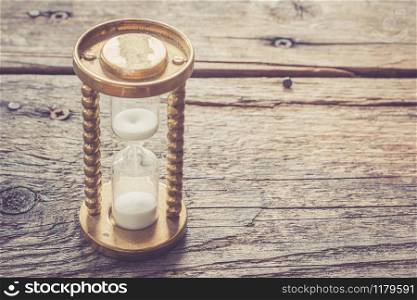 Hourglass on wooden desk, close up picture