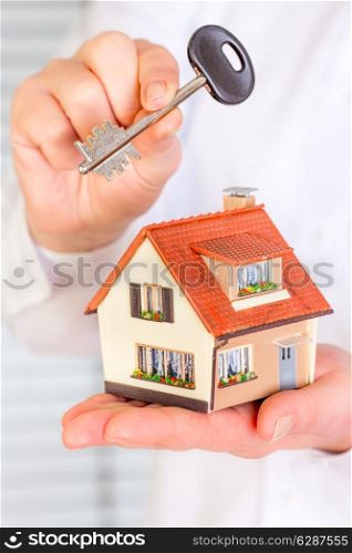 House an key in human hands on a white background