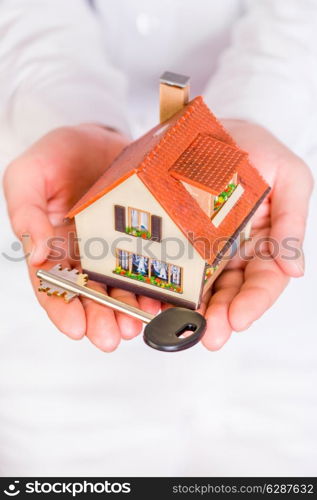 House an key in human hands on a white background