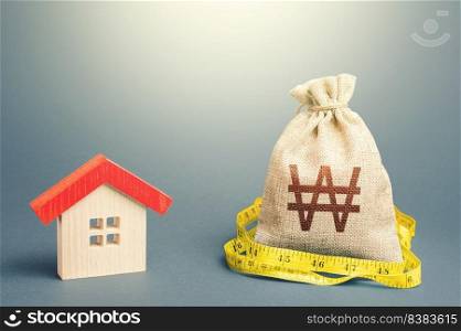House and south korean won money bag. Mortgage loan. Buying and selling, fair price. Building maintenance. Calculation of expenses for purchase, construction and repair. Property real estate valuation