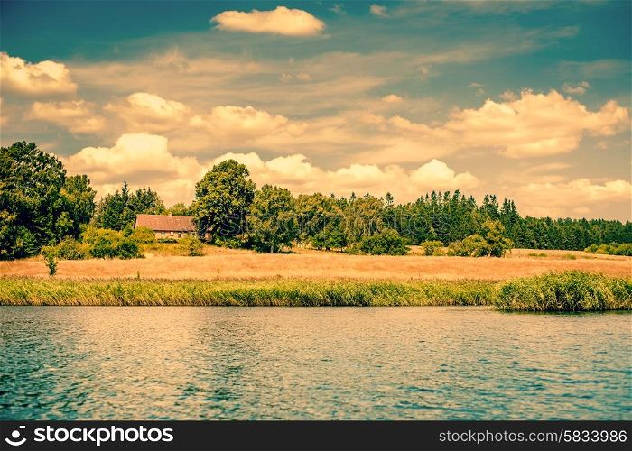 House by a riverside surrounded by fields and trees