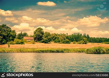 House by a riverside surrounded by fields and trees