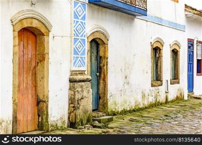 House facade in weather-damaged colonial architecture on cobblestone street in the historic city of Paraty in the state of Rio de Janeiro, Brazil. House facade in weather-damaged colonial architecture on cobblestone street