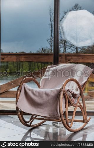 House furniture. Comfortable armchair with blanket on it in daylight with window in background. Comfortable armchair with window in background