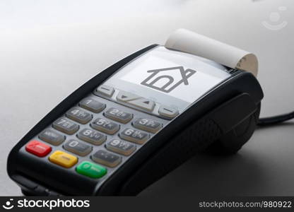 House icon on credit card machine for property concept