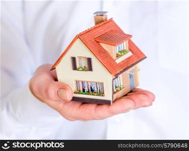 house in human hands on a white background