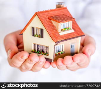 house in human hands on a white background