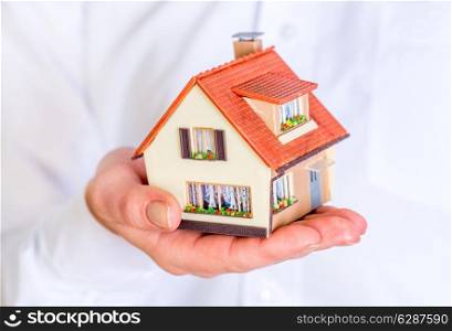 House in human hands on a white background