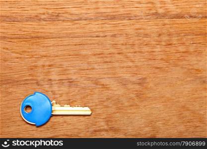 House key with blue plastic coats caps on wooden table background. Copy space for text