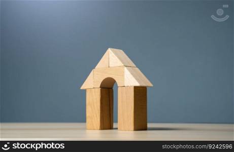 House made of wooden figures on a gray background. Buying and selling housing. Design and architectural services. Real estate market review. Construction industry. Property insurance.