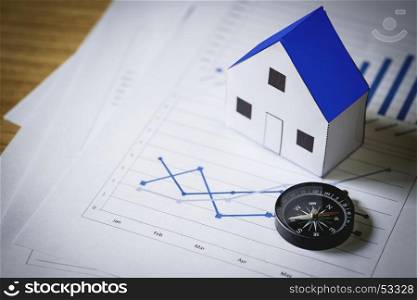 House model and compass on plan background, Real estate concept.