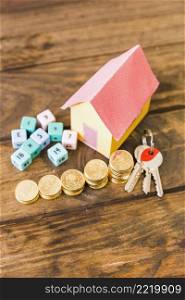 house model key math blocks stacked coins wooden backdrop