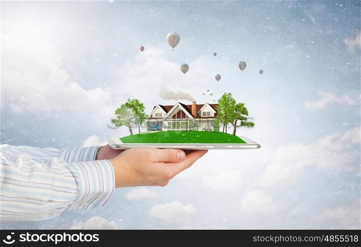 House model on tablet screen. Male hands holding tablet pc with house model on screen