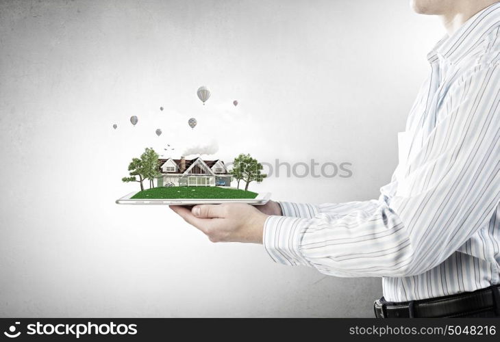 House model on tablet screen. Male hands holding tablet pc with house model on screen