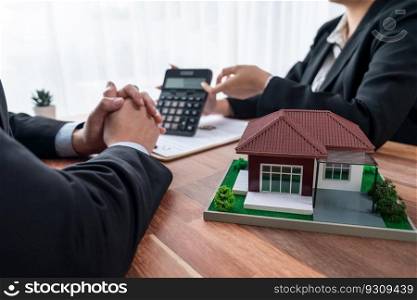 House model s&le on wooden table with blurred background of real estate agent and buyer or client discussing terms and condition on house loan contract. Housing business meeting. Jubilant. House model s&le on wooden table with blurred background. Jubilant