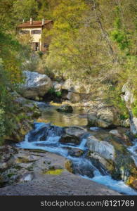 House near the mountain river in the Alps