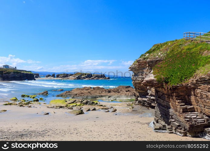 House on cliff and summer Atlantic sandy beach Los Castros (Galicia, Spain).