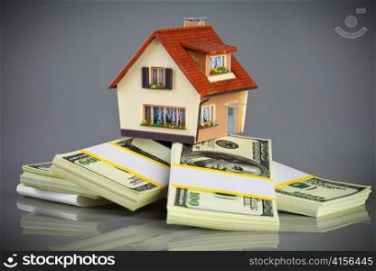 house on packs of banknotes on a grey background
