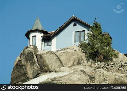House on top of the mountain on a rocks