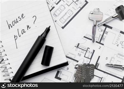 house plan with question mark sign written notebook with felt tip pen keys blue print