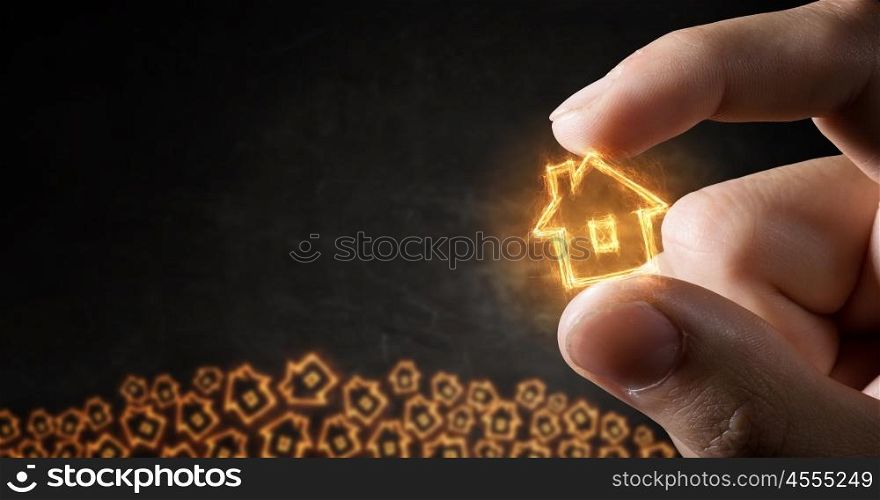 House sign between fingers. Close view of male hand taking with fingers house symbol