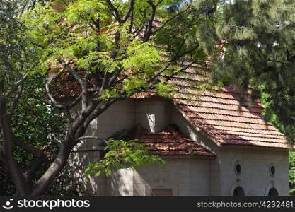 house with a tiled roof and green trees