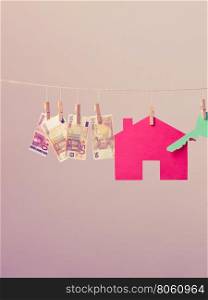 House with key and banknotes. Red house with green key and banknotes cash hang on laundry line. Selling and buying home concept.