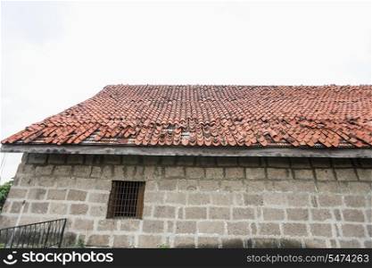 House with tiled roof and stone wall in Manila; Philippines