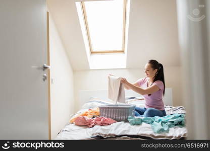 household and people concept - woman or housewife sorting laundry at home. woman or housewife sorting laundry at home. woman or housewife sorting laundry at home