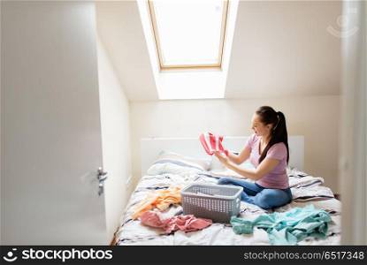 household and people concept - woman or housewife sorting laundry at home. woman or housewife sorting laundry at home. woman or housewife sorting laundry at home
