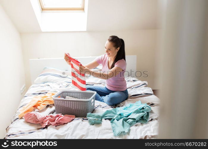 household and people concept - woman or housewife sorting laundry at home. woman or housewife sorting laundry at home. woman or housewife sorting laundry at home