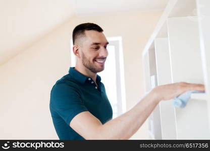 household, cleaning and people concept - man wiping shelf with cloth at home. man cleaning shelf with cloth at home. man cleaning shelf with cloth at home