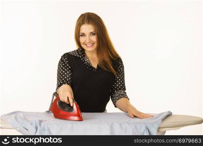 Household duties, taking care of clothes concept. Happy woman standing behind board ironing clothing. Happy woman doing ironing