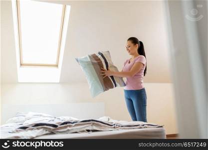 household, housework and cleaning concept - happy woman or housewife making bed at home. happy woman or housewife making bed at home. happy woman or housewife making bed at home