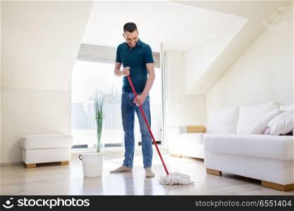household, housework and people concept - happy man with mop and bucket cleaning floor at home. man with mop and bucket cleaning floor at home. man with mop and bucket cleaning floor at home