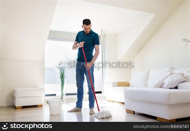household, housework and people concept - happy man with mop and bucket cleaning floor at home. man with mop and bucket cleaning floor at home. man with mop and bucket cleaning floor at home