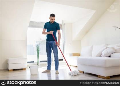 household, housework and people concept - man with mop and bucket cleaning floor at home. man with mop and bucket cleaning floor at home. man with mop and bucket cleaning floor at home