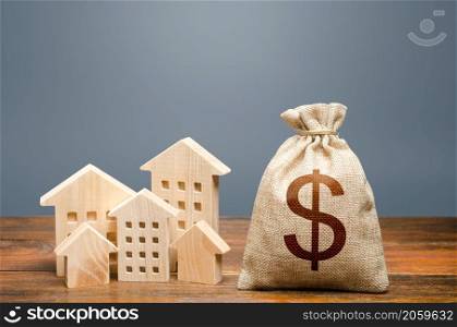 Houses and dollar money bag. Community municipal budget. Investments in real estate and construction industry. Overheated market. Energy efficiency and costs for heating and home services.